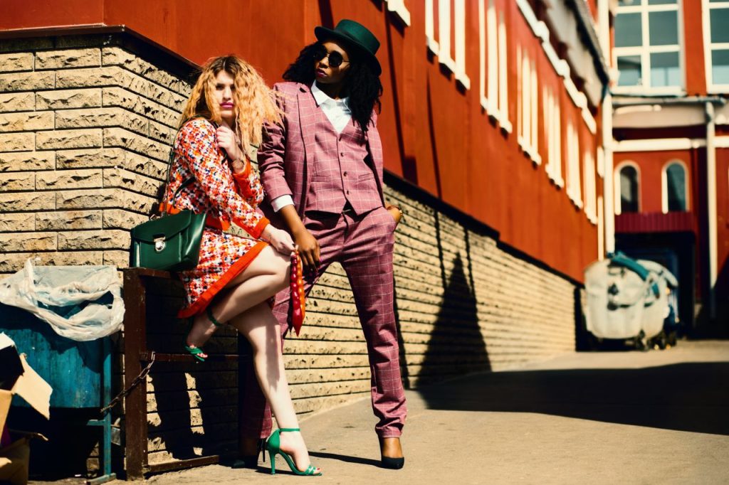 Mastering the First Impression: Your intriguing post title goes here Fashionable duo posing outdoors in vibrant outfits, embracing urban style and confidence.